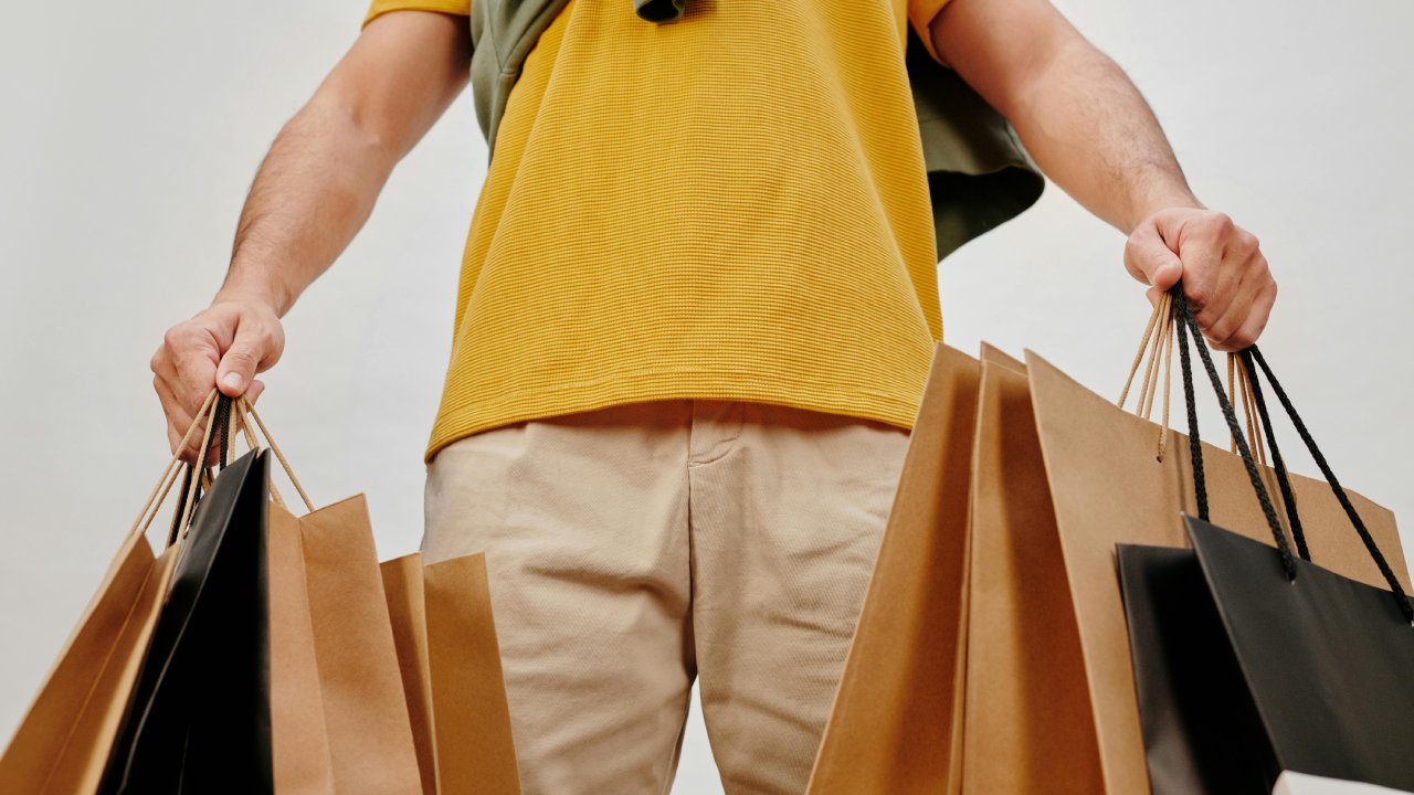 Deal Websites Feature Man Holding Shopping Bags