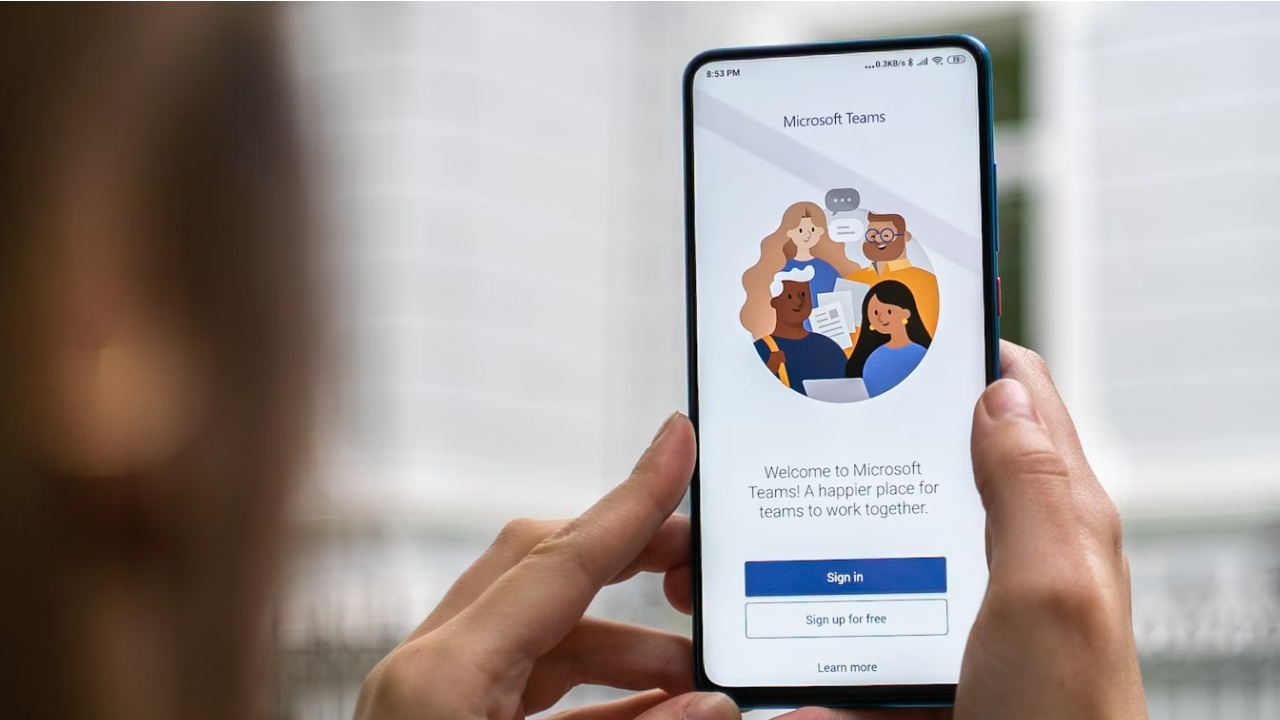 Person holding a phone with Microsoft Teams app.