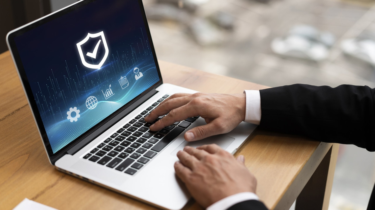 hands on a laptop with security check on the screen