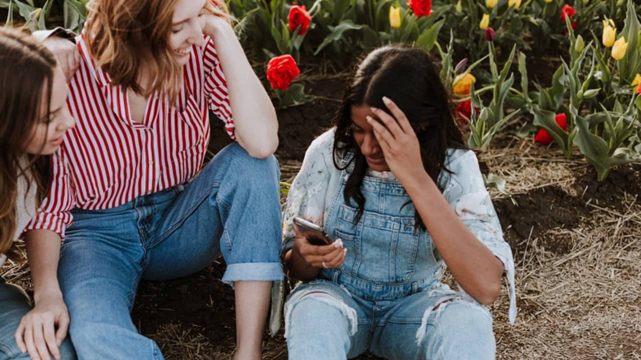 Group of friends looking at Instagram Blend on phone.