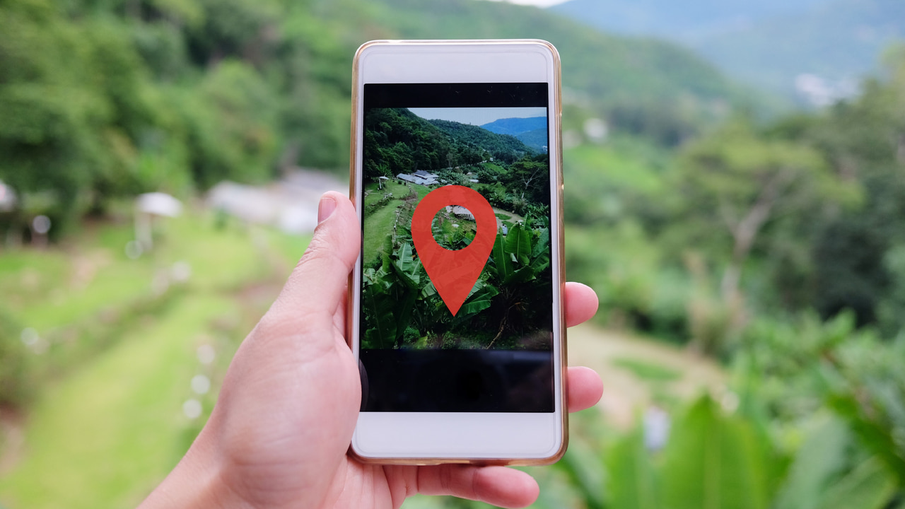 Woman hand holding smartphone for take a photo beautiful landscape valley mountain with a location pin