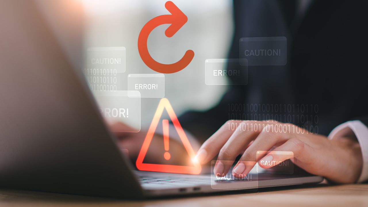 Man working on laptop with errors and caution signs