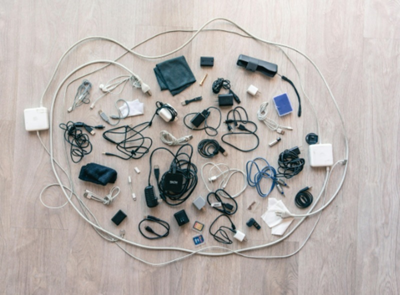 Mess of cables and chargers on a table.