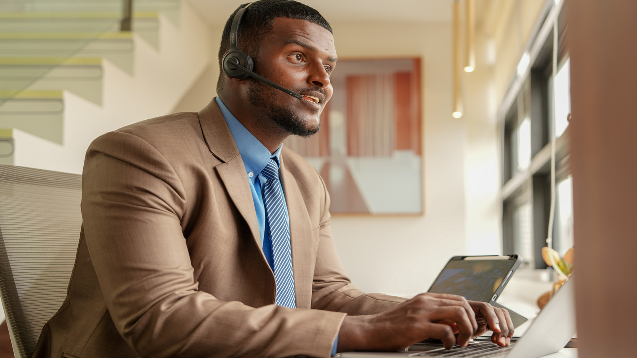 man working on laptop with headphones on head