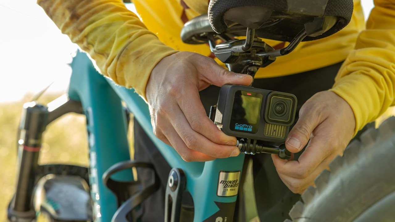 Man Attaching GoPro Camera to Bike Before Riding in Mountains