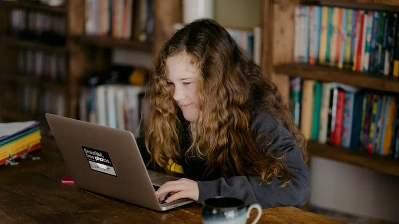 Teen learning on a laptop.