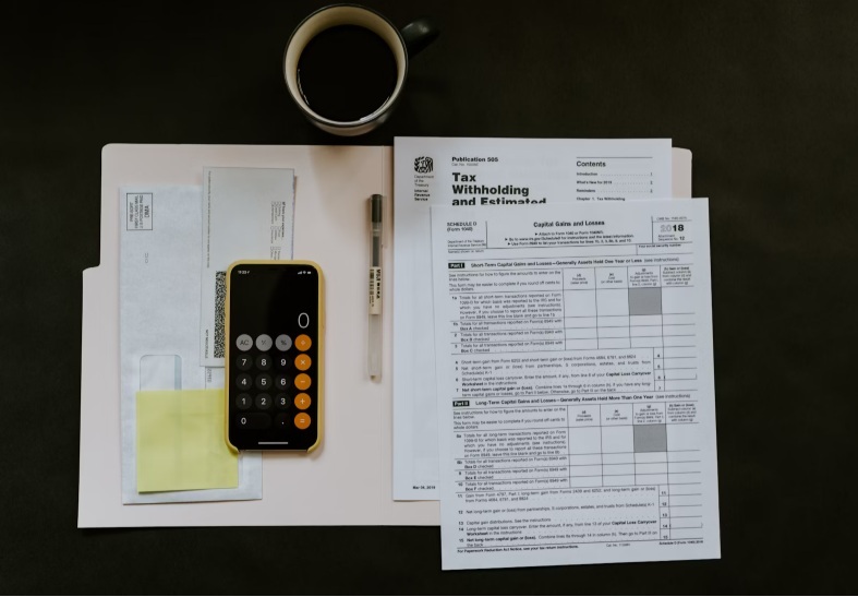 Tax documents near coffee mug.