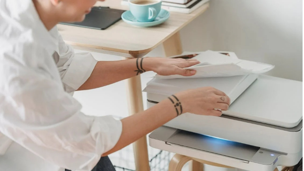 Woman loading paper in a printer.