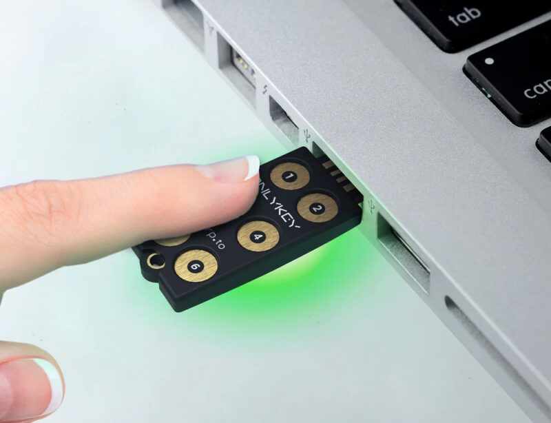 Onlykey inserted in a laptop with a finger on it