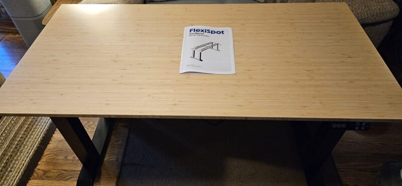 FlexiSpot desk with instructions on top.
