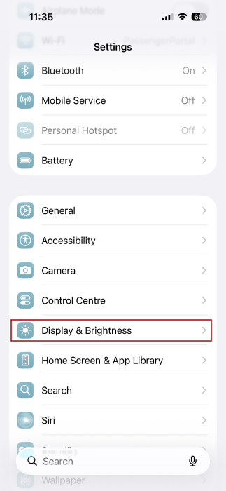 Tapping on "Display & Brightness" option in iPhone Settings. 