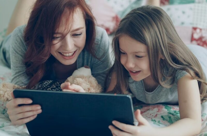 Mom and daughter watching movies on a tablet.