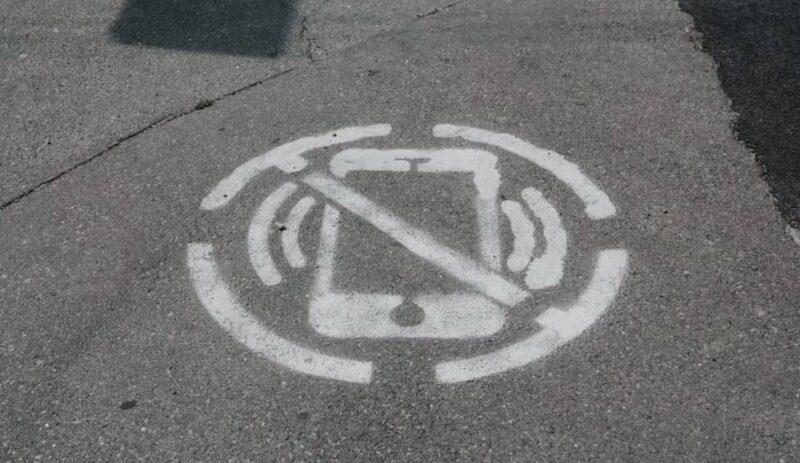 Concrete sidewalk with a no phone sign drawn on it.