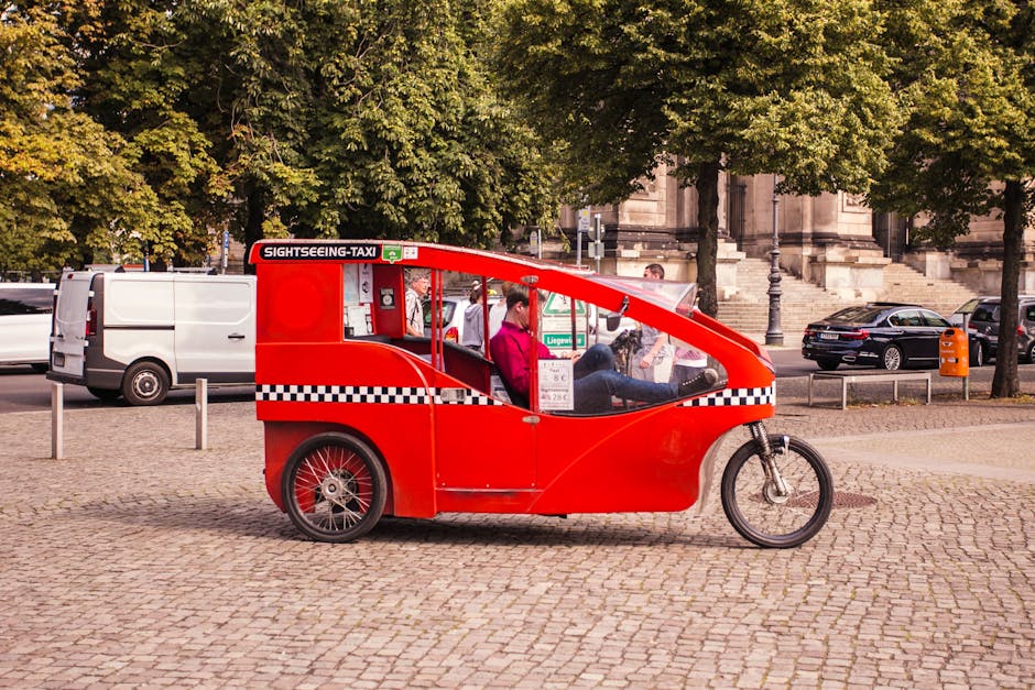 Red sightseeing tricycle taxi on a city street, offering a unique tour experience.