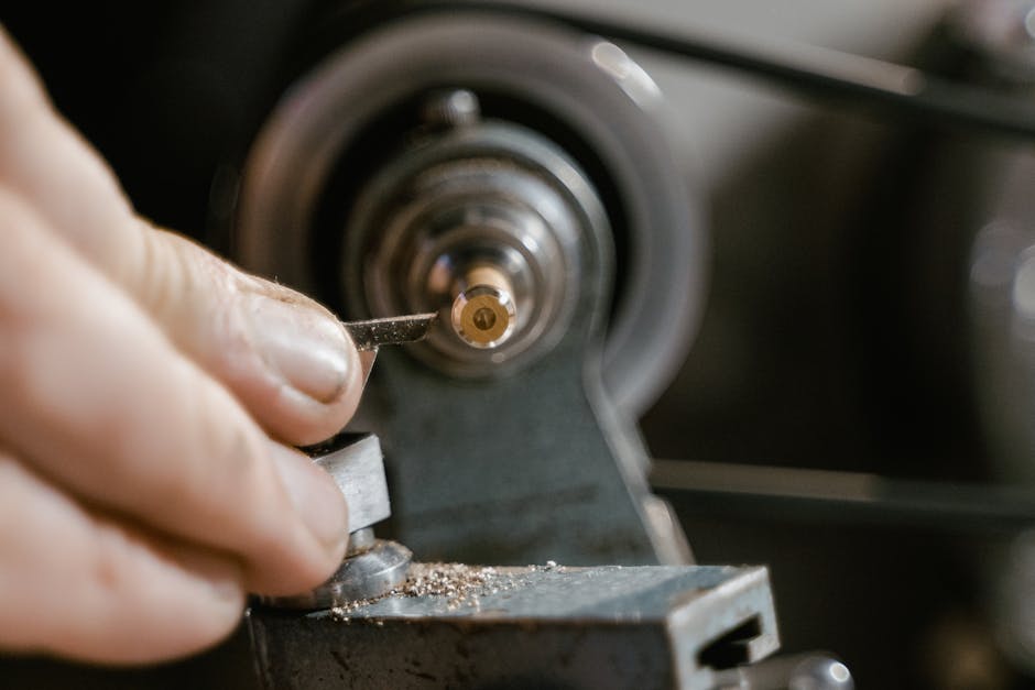 Detailed view of hands crafting a metal component on a lathe. Precision and skill in focus.