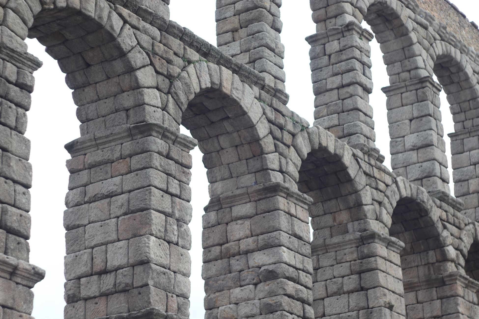 Close-up view of the historic Roman Aqueduct in Segovia, showcasing its stone arches and classic architecture.