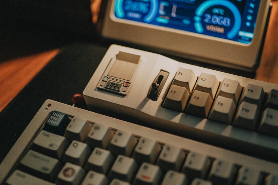 Apple’s original 1984 Macintosh keyboard had no arrow keys, no function keys, and no numeric pad because Steve Jobs wanted users to reach for the mouse first. Then Apple quietly sold the missing keys as an accessory.